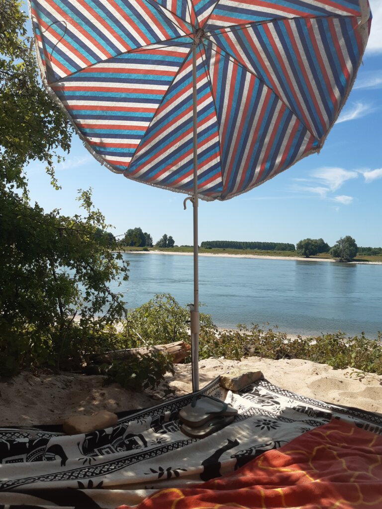 Schaduw van de sgesrteepte parasol op Naaktstrand Loenensche Buitenpolder