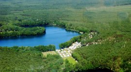 Bovenaanzicht van de bosrijke naturistencamping Tonsee en het meer