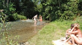 spelen in het riviertje op naturistencamping Domaine de l’Eglantière