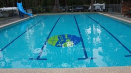 Mooi groot zwembad met glijbaantje op naturistencamping Rosco Club Australië