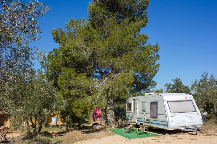 Grote ruime kampeerplekken voor caravans, met schaduw van de bomen op naturistencamping Sierra Natura