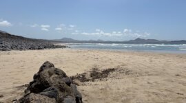 Naaktstrand Playa Famara is omgeven door zwarte rotsen