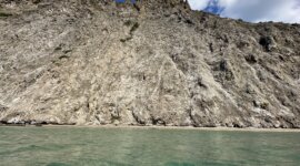 kristalheldere zee en rotswand van Naaktstrand Melia Dahfni