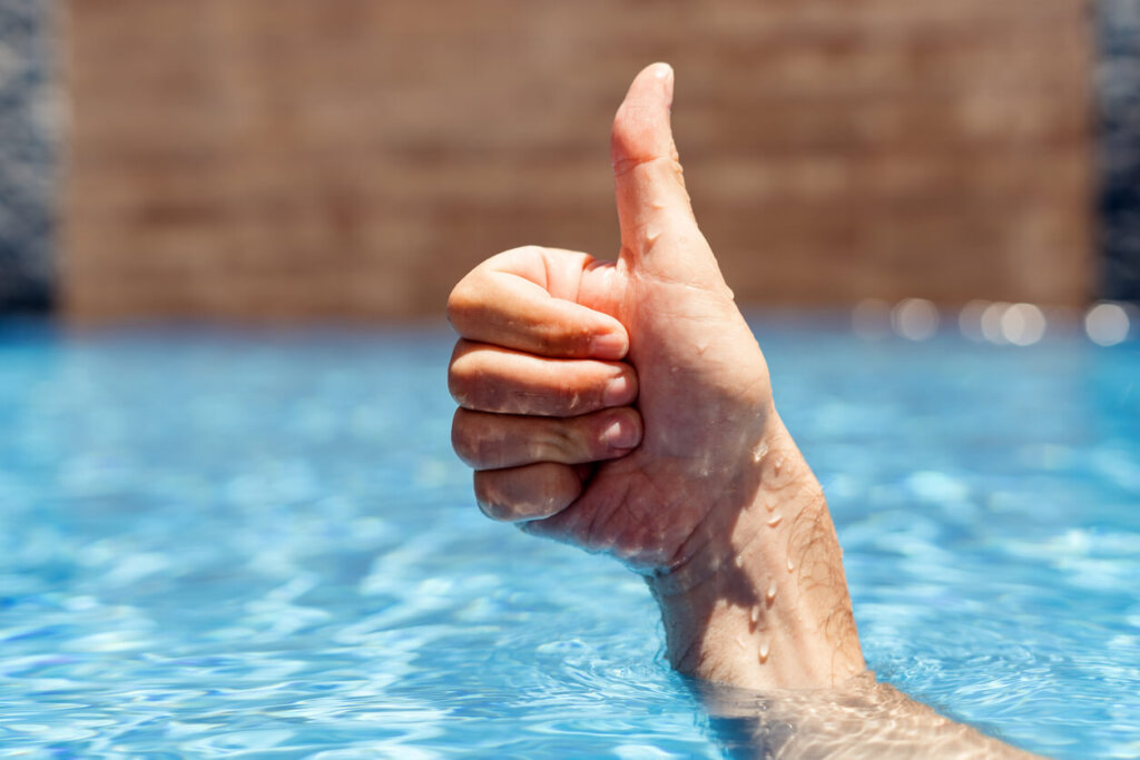 man steekt duim omhoog tijdens naakt zwemmen