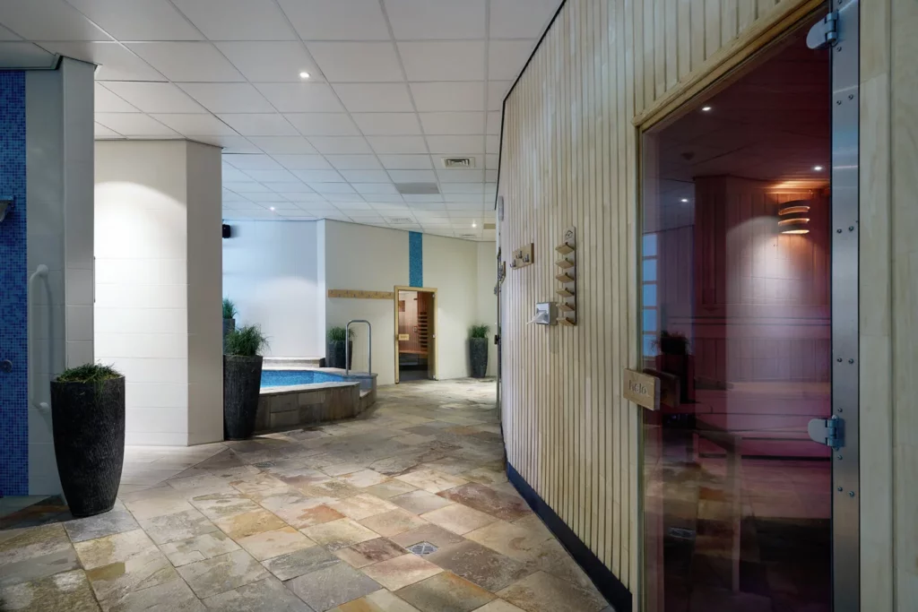 Moderne wellnessruimte met houten sauna en relaxstoelen bij Hotel HUP in Mierlo op BlootKompas