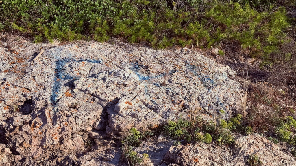 FKK geschilderd op rotsen op naaktstrand Milia Beach