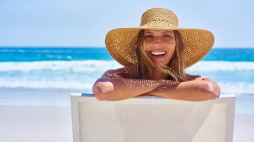 Portret van een aantrekkelijke jonge vrouw die geniet van een vakantie aan het strand